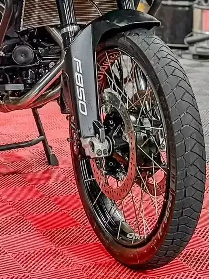 Roda dianteira, disco de freio e raios de uma moto no estúdio