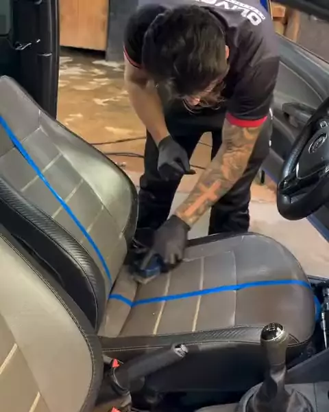 Limpeza de banco de couro com luvas dentro de um carro