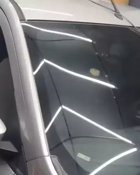 Linhas de luz de LED refletidas na pintura de um carro para inspeção
