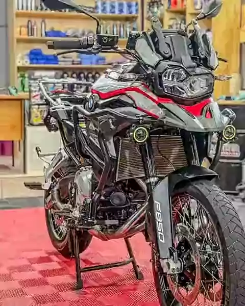 BMW F 850 GS no estúdio da Oliveira, com prateleiras de produtos ao fundo