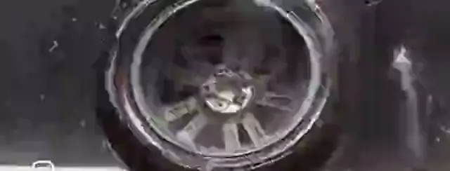 Roda lavada fora do carro, com espuma.